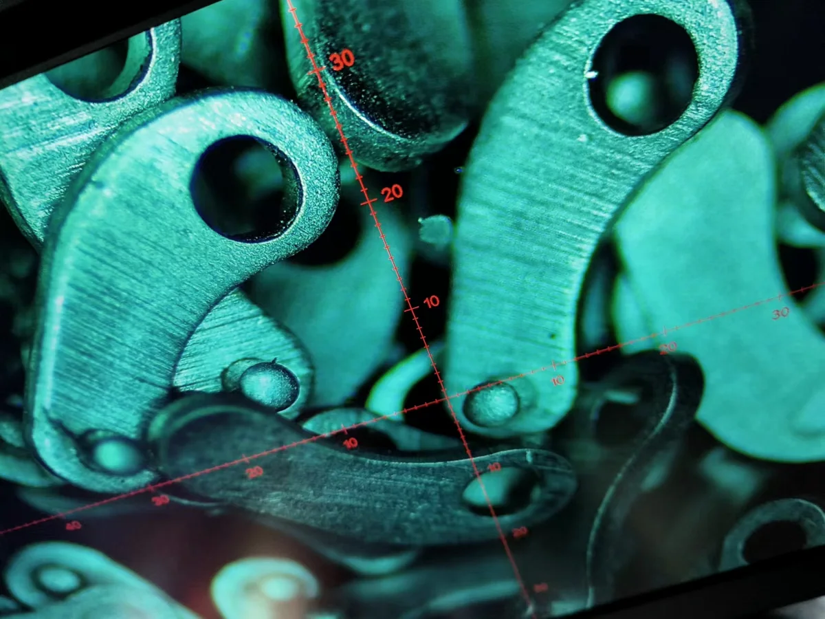 Miniature linkage components viewed under magnification